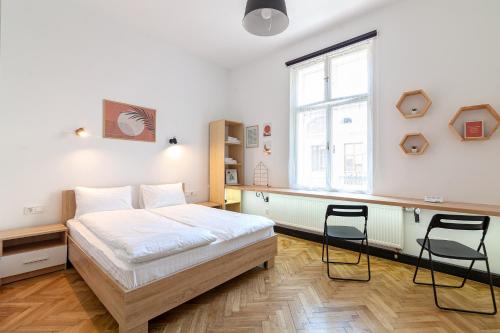 a bedroom with a bed and two chairs in it at Check-in Apartments in Lviv