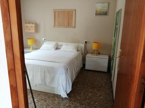 a bedroom with a bed and two lamps on a night stand at "Cal Tu" in San Fausto de Campcentellas