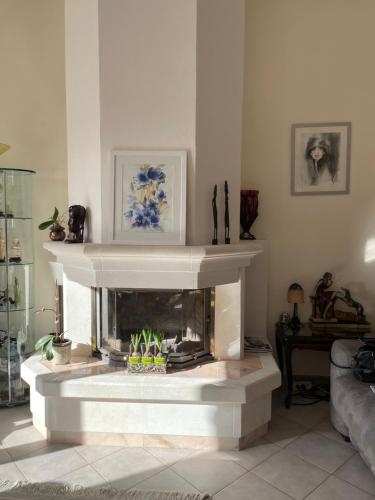 a white fireplace in a living room with a fire place at Villa 180 m2 piscine in Draguignan