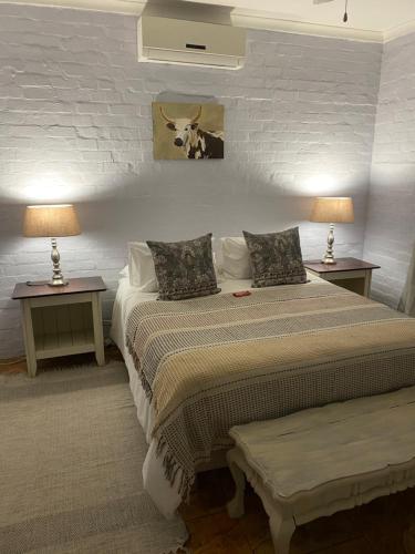 a bedroom with two beds and two tables with lamps at Die Kothuis in Malelane