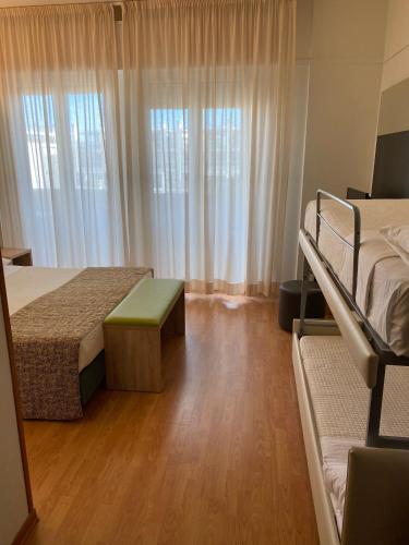 a bedroom with two beds and a wooden floor at Hotel St Gregory Park in Rimini