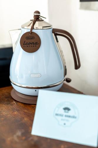 a tea kettle on a table with a sign on it at Deniz Kabugu Hotel in Alacati