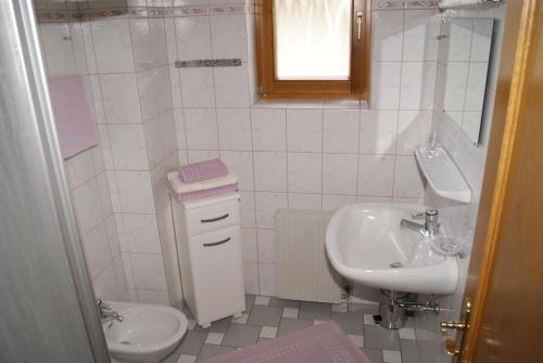 ein weißes Bad mit einem Waschbecken und einem WC in der Unterkunft Ferienwohnungen Gerti in Klopein am Klopeiner See