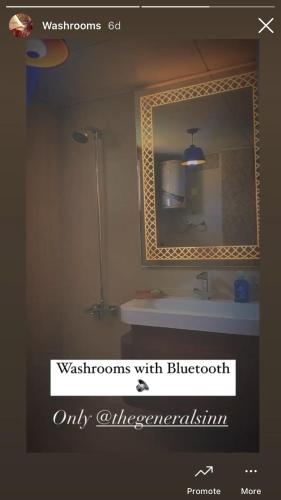 a bathroom with a mirror and a white sink at The Generals Inn in Bhurban