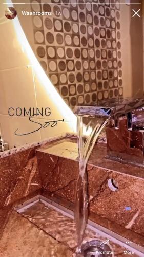 a stream of water coming out of a bathroom sink at The Generals Inn in Bhurban