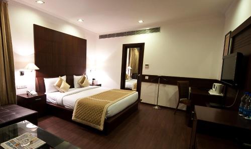 a hotel room with a bed and a desk at Divine Paradise Tavisha in New Delhi