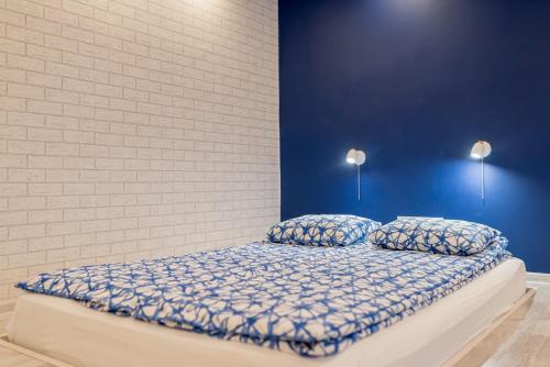 a bed in a room with a blue wall at Lux Apartment in white in Gdańsk