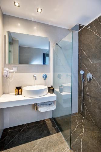 a bathroom with a sink and a shower at Epicentrum Suites in Limenaria
