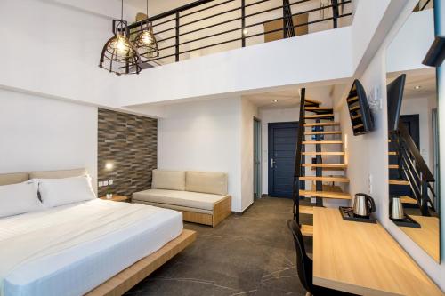 a bedroom with a bed and a spiral staircase at Epicentrum Suites in Limenaria