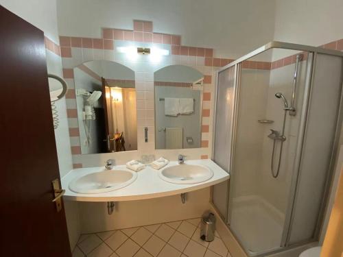 a bathroom with two sinks and a shower at Hotel Kaiser Franz Josef in Millstatt