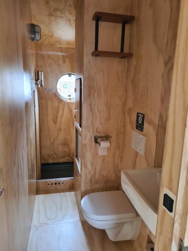 een kleine badkamer met een toilet en een wastafel bij Wikkelboat Nr1 at Floating Rotterdam Rijnhaven in Rotterdam