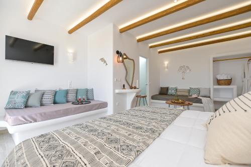 a white bedroom with a bed and a couch at Marine Dream in Plaka