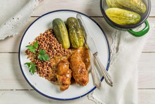 a plate of food with chicken and beans and pickles at Pokoje De Luxe Figaro in Płock