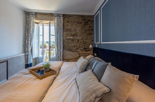 a bedroom with a large bed with a table on it at ABASTOS BELLA BOUTIQUE in Santiago de Compostela
