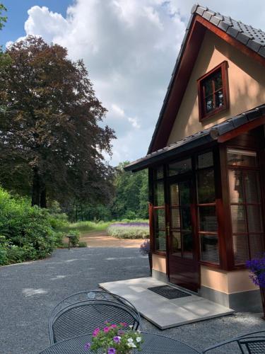 a small building with a table and flowers at Romantisch Gastenverblijf 'Het Vogelhuisje' in Lunteren