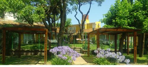 un jardín con flores púrpura frente a un edificio pucará en Villa Gesell