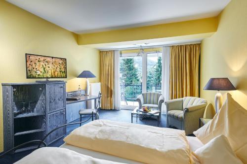 a hotel room with a bed and a desk at Rüters Parkhotel in Willingen