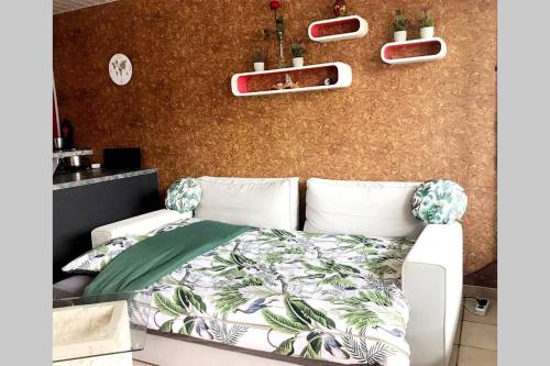 - une chambre dotée d'un lit blanc avec des plantes sur le mur dans l'établissement Adorable studio cabine vue mer - 2/4 personnes, à Saint-Jean-de-Monts