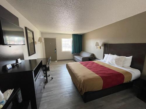 a hotel room with a bed and a couch at Motel 6 Hermiston OR Umatilla in Hermiston