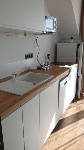 een keuken met witte kasten en een wastafel bij Apartmány U Našich in Horní Lipka