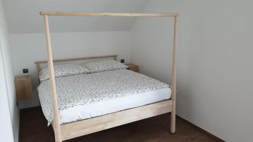 Apartmány U Našich في Horní Lipka: سرير أبيض مع ستارة في غرفة النوم