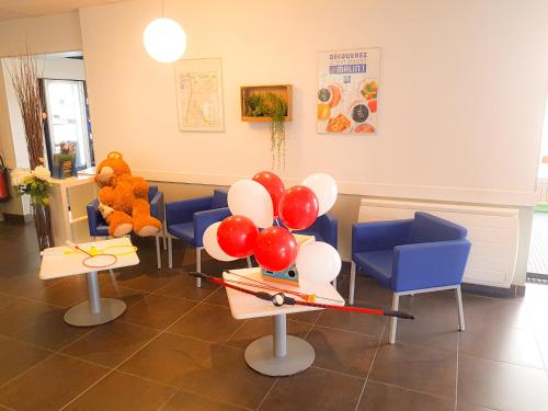 a waiting room with balloons and a teddy bear at ibis budget Marne la Vallée in Saint-Thibault-des-Vignes