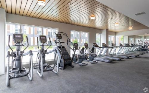 a gym with a row of tread machines in a room at Lux House Of Champagne 2BR 2BA Free Parking & Wifi in Baltimore