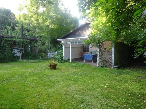 un patio con un cobertizo y una silla en el patio en Feriehus stråtækt bindingsværksidyl, en Maribo