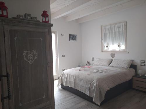 a bedroom with a bed and a dresser and a window at Idroblu Bondone Lago d'Idro in Bondone
