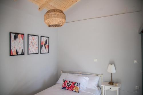 a bedroom with a bed with a lamp and pictures on the wall at Rena's Panorama View House in Vovikes