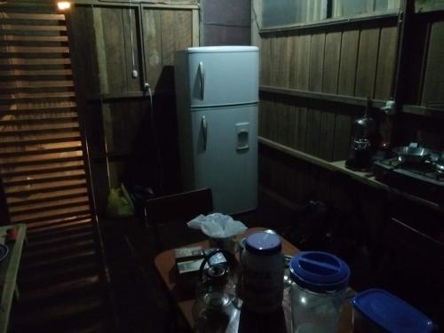 a small kitchen with a table and a refrigerator at Don Jaime - Hostel in Puerto Maldonado