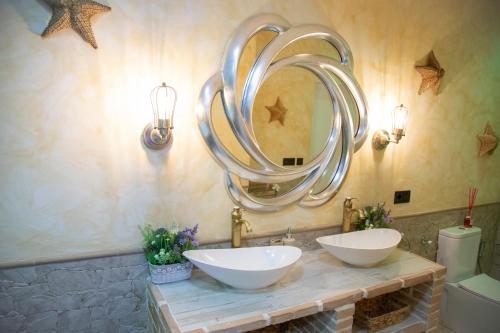 a bathroom with two sinks and a large mirror at APARTAMENTO ESTRELLA SAUNA SPa JACUZZI in Alhama de Aragón