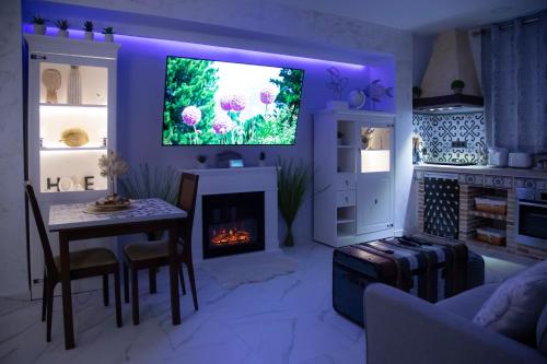 a living room with a tv and a table and a fireplace at APARTAMENTO ESTRELLA SAUNA SPa JACUZZI in Alhama de Aragón