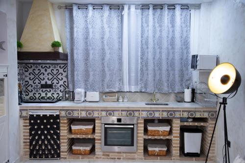 a kitchen with a counter with a stove and a sink at APARTAMENTO ESTRELLA SAUNA SPa JACUZZI in Alhama de Aragón