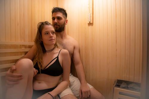 a man and a woman sitting in a sauna at APARTAMENTO ESTRELLA SAUNA SPa JACUZZI in Alhama de Aragón