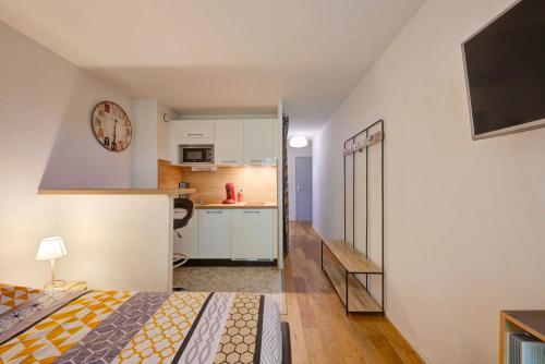 a small apartment with a kitchen and a bed in a room at Le Brienne Toulouse Centre in Toulouse