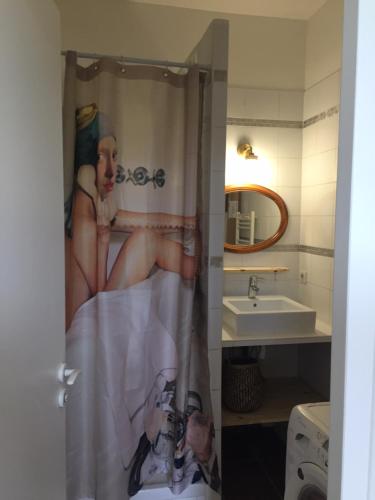 - une salle de bains pourvue d'un rideau de douche avec une photo de femme dans l'établissement Typique T2 Terrasse situé Quartier Panier Vieux Port, à Marseille