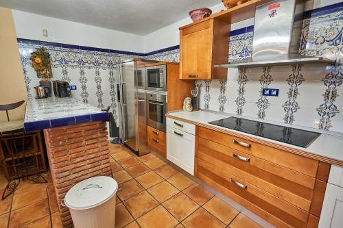a kitchen with wooden cabinets and a tile floor at Garai Etxea, casa adosada en la montaña in Arrankudiaga