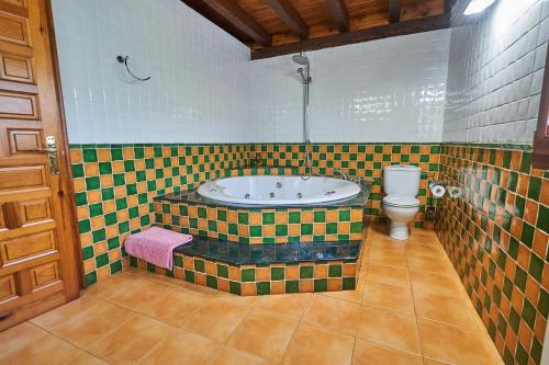 a bathroom with a tub and a toilet at Garai Etxea, casa adosada en la montaña in Arrankudiaga