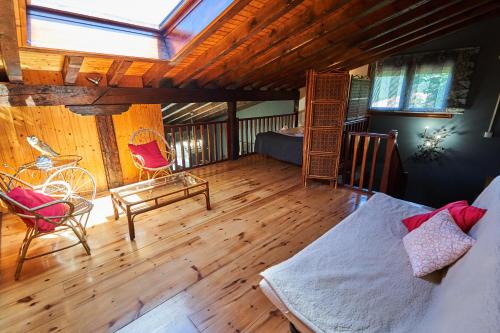 a room with a bed and chairs and a skylight at Garai Etxea, casa adosada en la montaña in Arrankudiaga