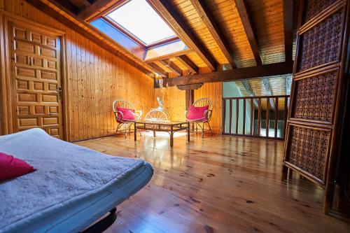 a bedroom with a bed and two chairs and a table at Garai Etxea, casa adosada en la montaña in Arrankudiaga