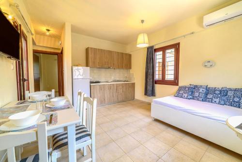 a kitchen and a living room with a bed and a table at Harmony House in Platanias