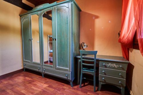a green cabinet with a chair next to a dresser at Garai Etxea, casa adosada en la montaña in Arrankudiaga