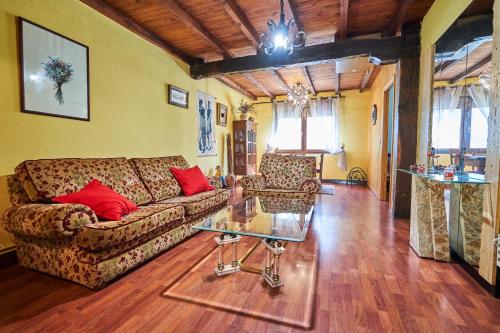 a living room with a couch and a glass table at Garai Etxea, casa adosada en la montaña in Arrankudiaga