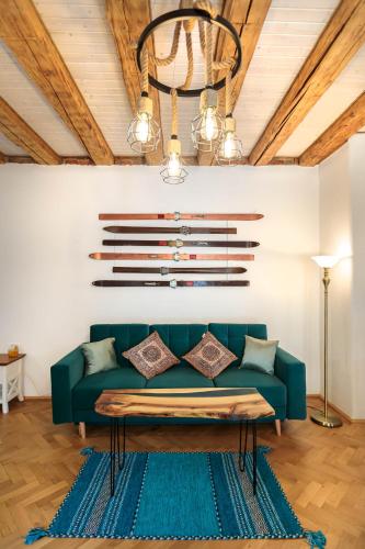 a living room with a green couch and a chandelier at Saint John's 22 Brasov in Braşov