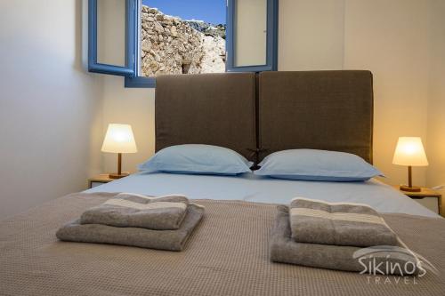 a bedroom with a bed with two towels on it at House Of Kastro in Sikinos