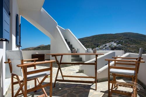 Un balcón con mesas y sillas en un edificio en House Of Kastro, en Síkinos