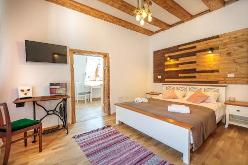 a bedroom with a bed and a desk and a television at Saint John's 22 Brasov in Braşov