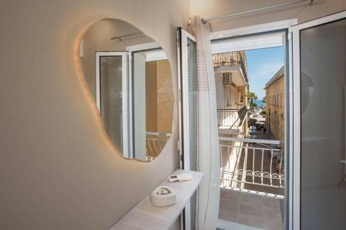 a bathroom with a mirror and a balcony at El Sueño de Zante 2nd City Center Apartments in Zakynthos Town