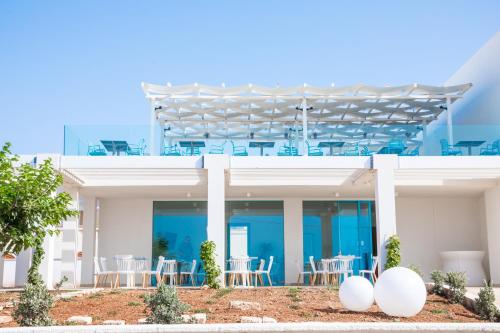 a white house with tables and chairs on it at Hotel Magna Grecia in Leuca